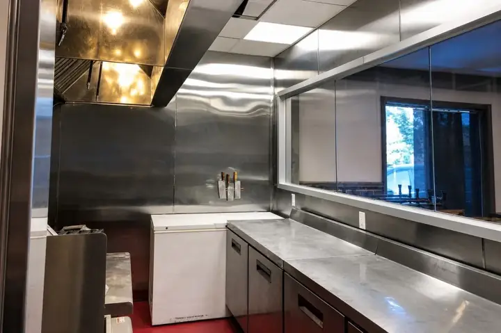 Finished commercial kitchen with stainless-steel ventilation hood