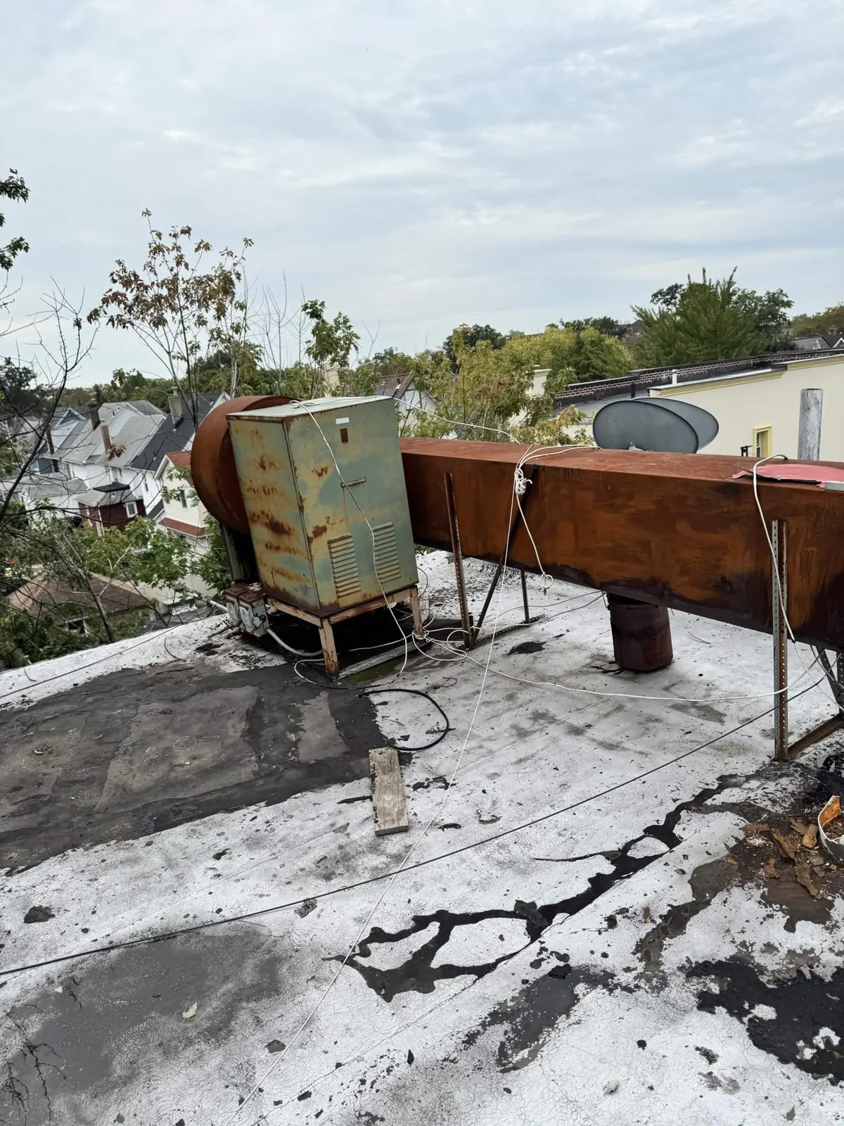 Old rusted rooftop fan and duct before the rebuild